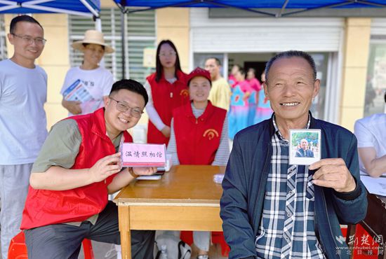 “溫情照相館”攤位上，前來照相的老人與志愿者開心地合影留念_副本.jpg