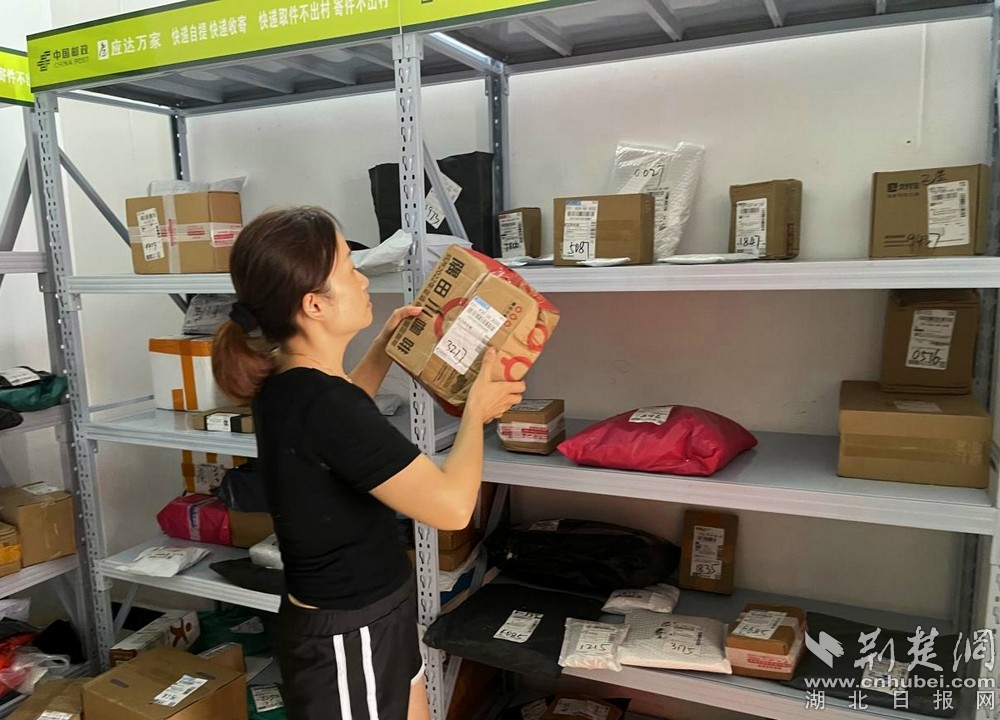 在城北街道西十村寄遞物流綜合便民服務(wù)站，站點(diǎn)負(fù)責(zé)人正在對(duì)快遞包裹進(jìn)行分類擺放  攝 余新怡攝.jpg